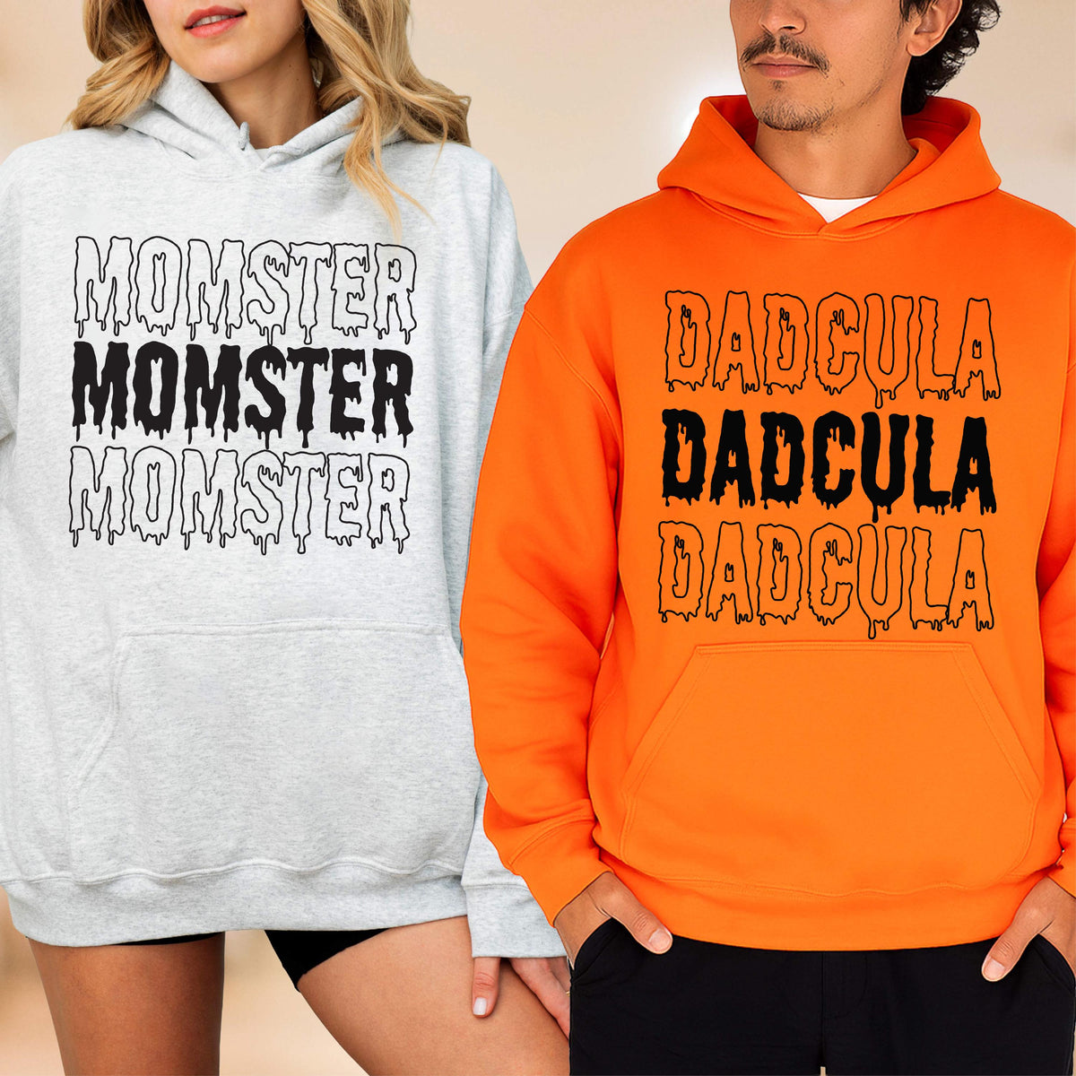 May include: Two hooded sweatshirts, one light gray and one orange. The gray sweatshirt has the word "MOMSTER" printed three times in black, dripping font. The orange sweatshirt has the word "DADcula" printed three times in black, dripping font.