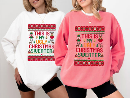 May include: Two sweatshirts, one white and one pink, each featuring a festive Christmas design. The design includes the text "THIS IS MY UGLY CHRISTMAS SWEATER" with holiday-themed graphics like a snowman, reindeer, and bells. The sweatshirts are a comfortable, casual style.