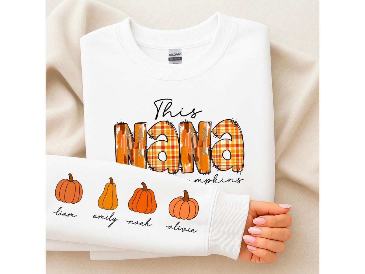 May include: White sweatshirt with the text "This NANA" in a plaid design, with the word "pumpkins" below. The sleeve features pumpkin illustrations and names: Liam, Emily, Noah, and Olivia.
