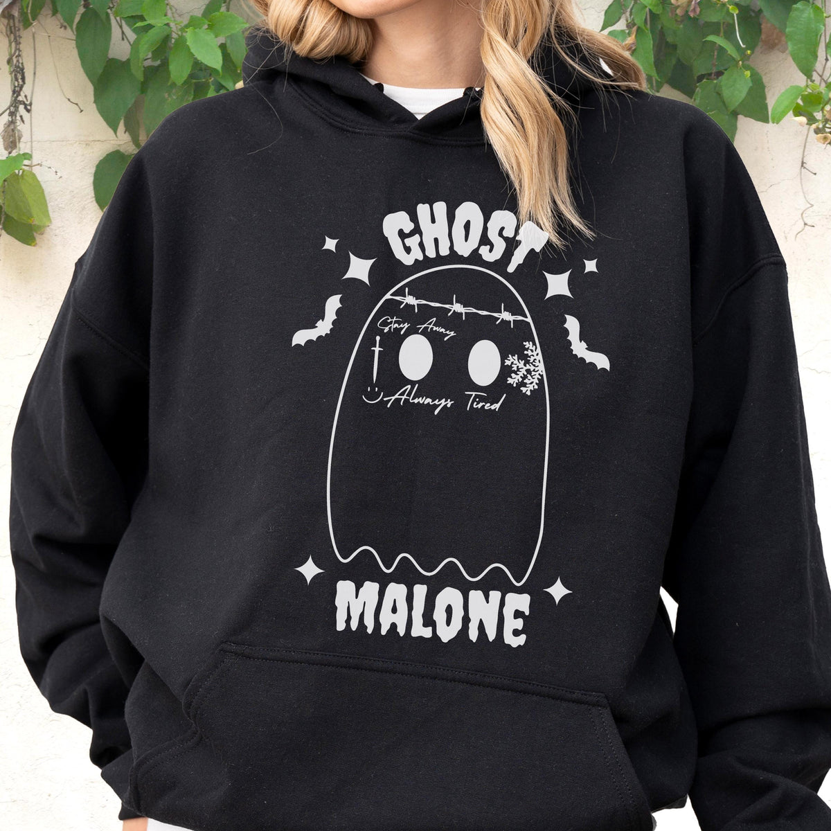 May include: Black hooded sweatshirt with a white ghost graphic. The ghost design includes the text "GHOST MALONE" and the phrases "Stay Away" and "Always Tired". The design also features bats, stars, and a snowflake.
