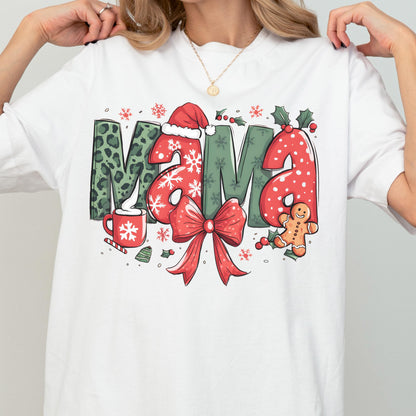 May include: White t-shirt with a festive "MAMA" graphic. The letters feature a mix of patterns: leopard print, snowflakes, and red polka dots. A red bow, gingerbread man, and Santa hat complete the holiday design.