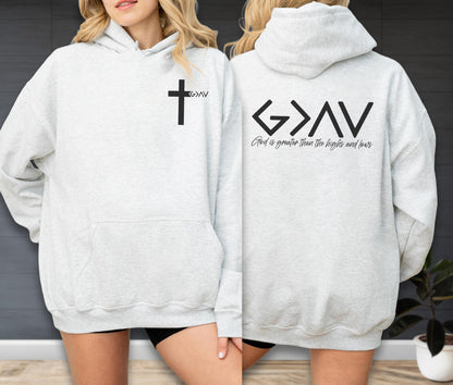 May include: A light gray hooded sweatshirt featuring a black cross graphic with the text G>AV on the front left chest. The back displays the large black text G>AV with the phrase God is greater than the highs and lows printed underneath.