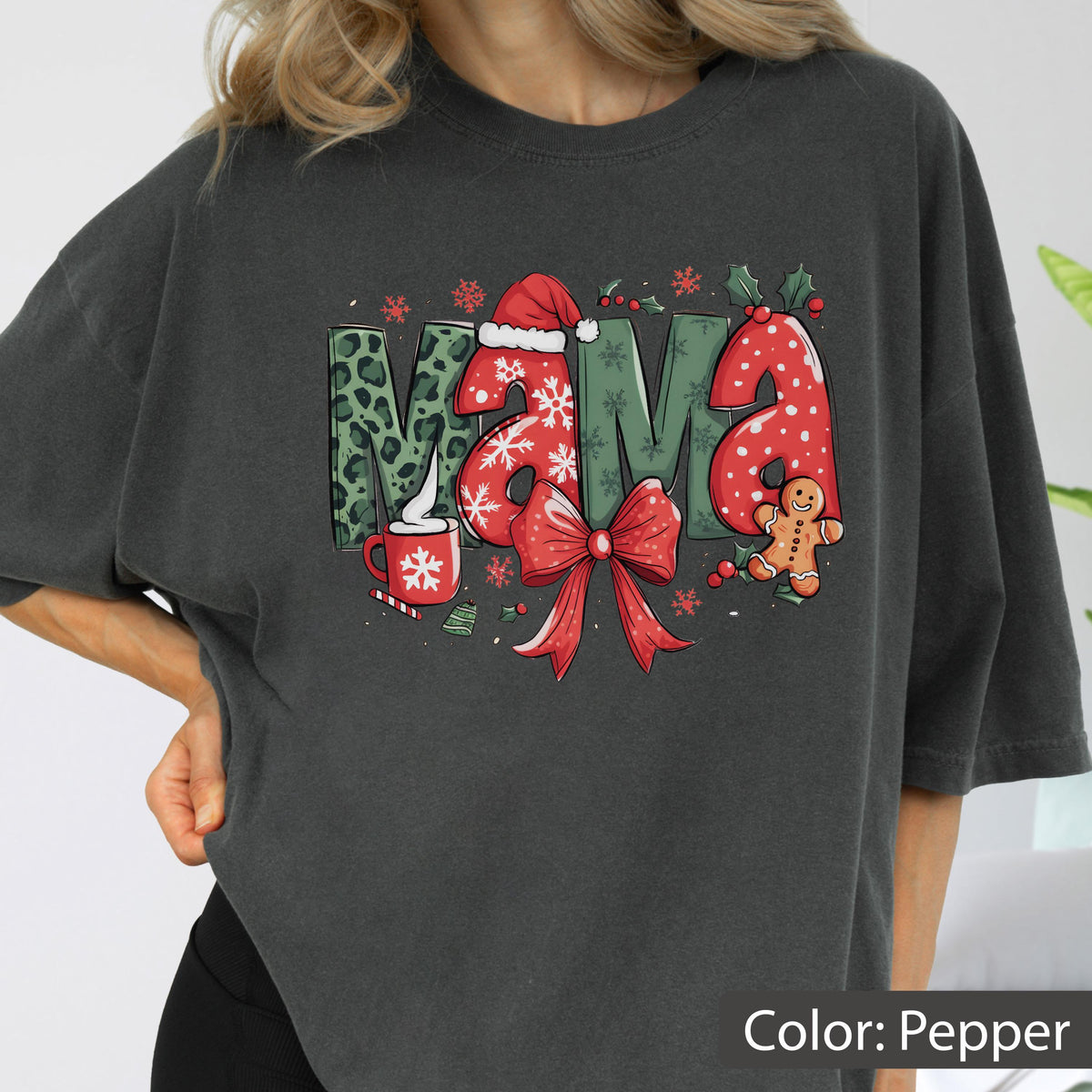 May include: Pepper-colored sweatshirt with the word "MAMA" in a festive Christmas design. The letters feature leopard print, snowflakes, and a Santa hat. A red bow and gingerbread man complete the holiday theme.