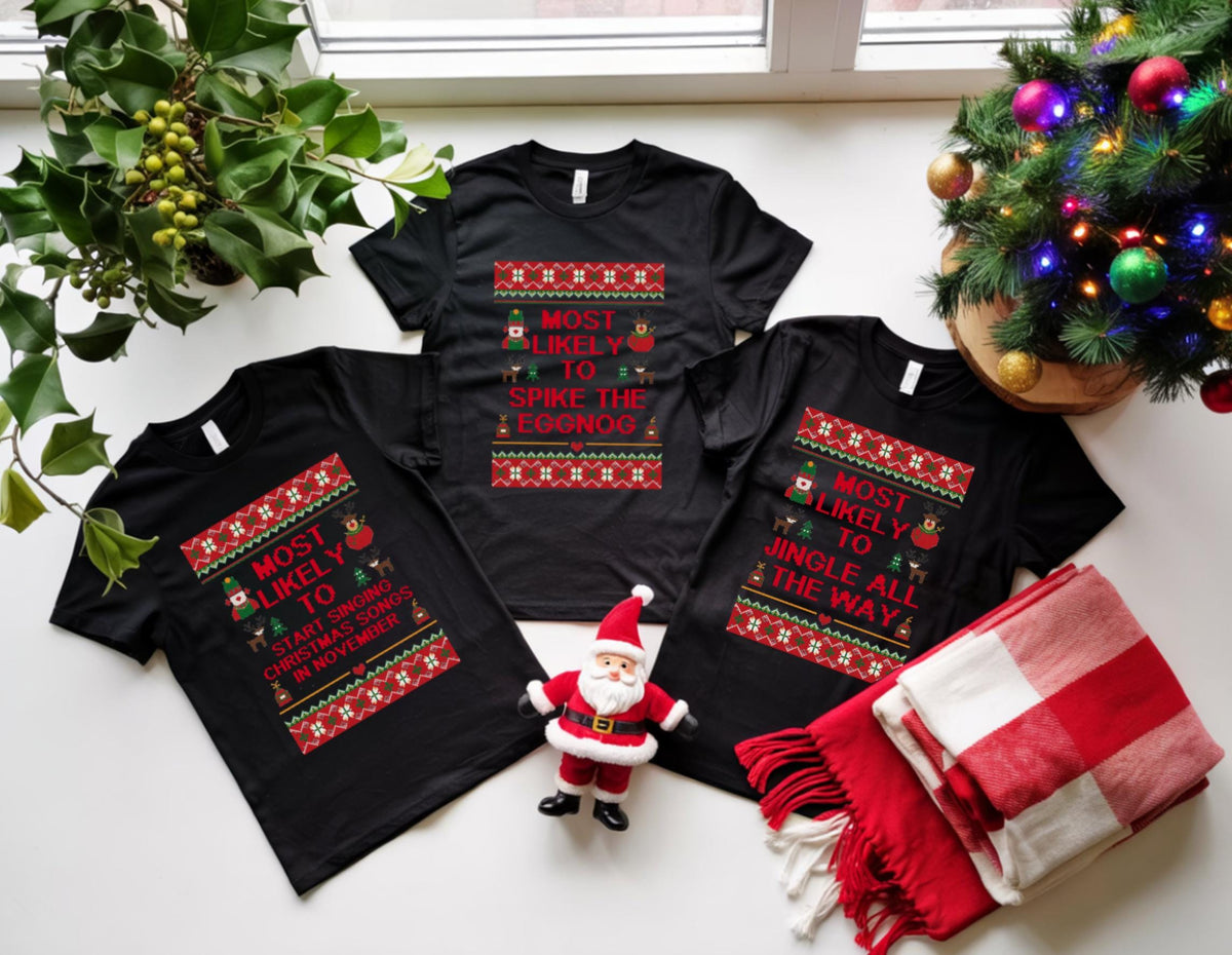 May include: Three black t-shirts with Christmas-themed text and designs. One shirt reads "Most Likely to Start Singing Christmas Songs in November." Another says "Most Likely to Spike the Eggnog," and the third says "Most Likely to Jingle All the Way."