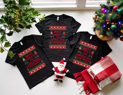 May include: Three black t-shirts with Christmas-themed text and designs. One shirt reads "Most Likely to Start Singing Christmas Songs in November." Another says "Most Likely to Spike the Eggnog," and the third says "Most Likely to Jingle All the Way."