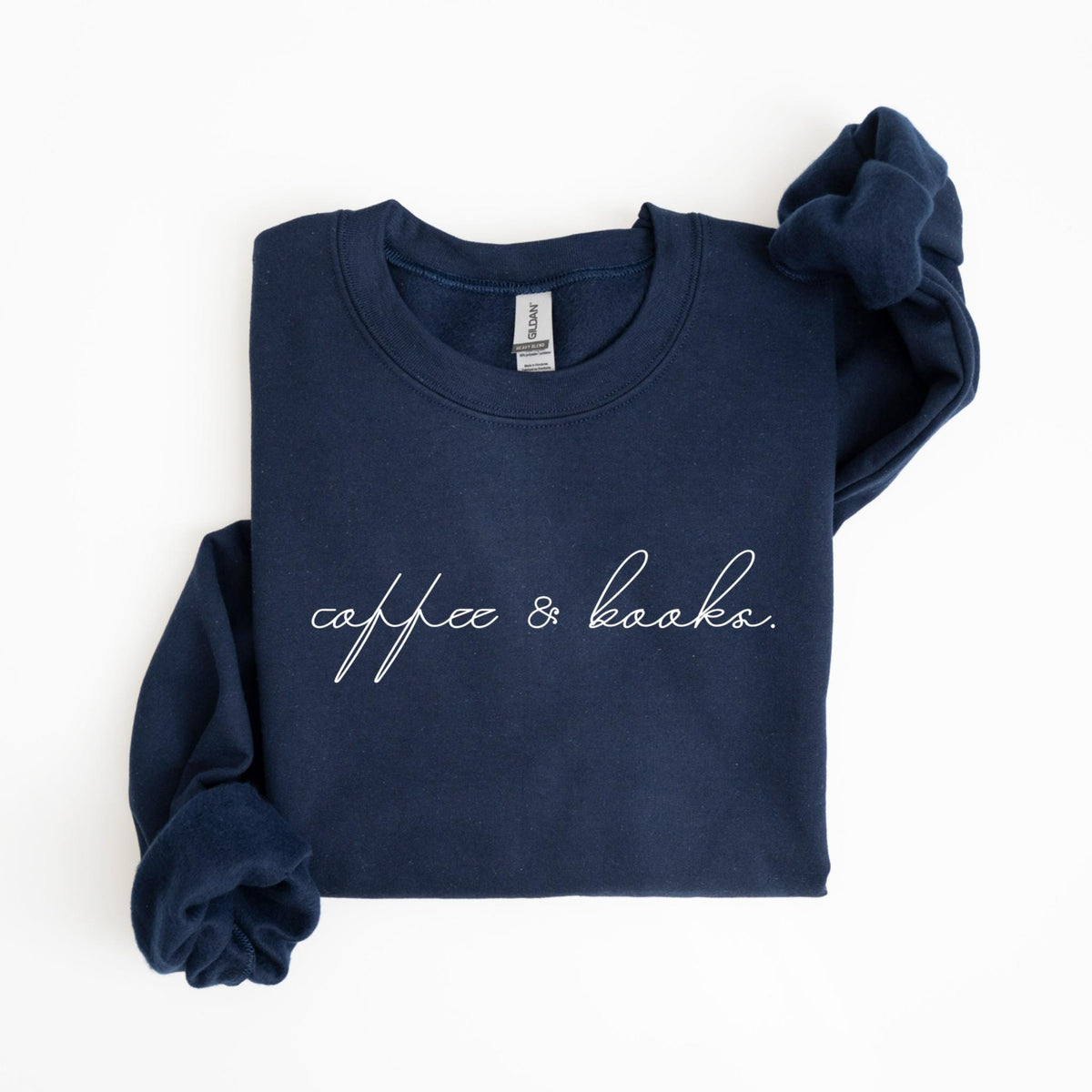 May include: Navy blue sweatshirt with the words "coffee & books" in a cursive font. The sweatshirt is folded and has a tag on the back of the neck. The sleeves are folded over the sweatshirt.
