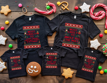 May include: Black t-shirts with Christmas-themed text and designs. The shirts have text that reads "Most Likely To..." followed by phrases like "Start Singing Christmas Songs in November" and "Jingle All The Way." Festive cookies and candy surround the shirts.
