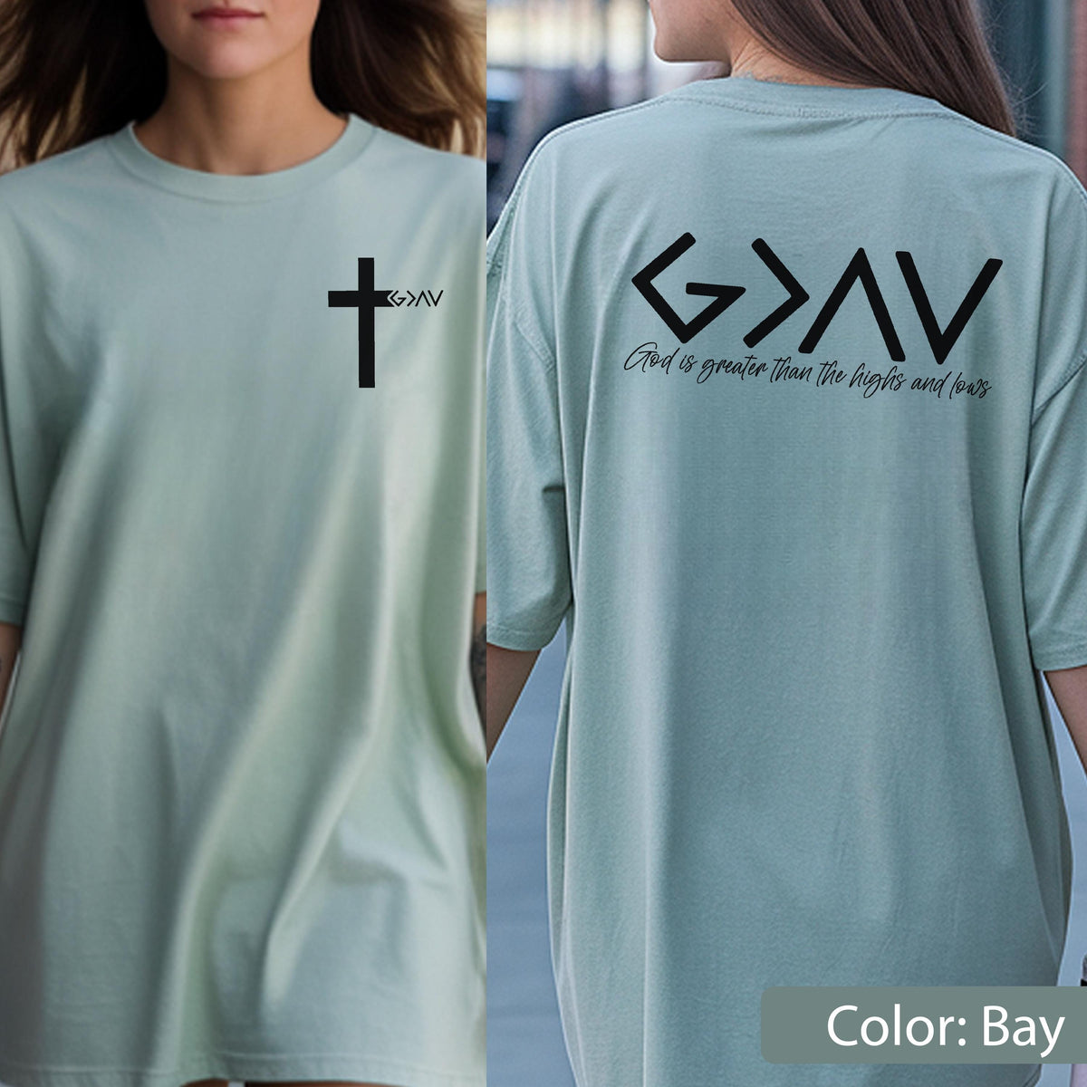 May include: A bay-colored short-sleeve t-shirt featuring a black cross graphic with the text G>AV on the front left chest. The back displays the large black text G>AV with the phrase God is greater than the highs and lows printed below it.
