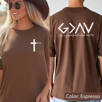 May include: An espresso brown t-shirt featuring a white cross and the text G>AV on the front left chest. The back displays the large white text G>AV with the script phrase God is greater than the highs and lows printed underneath in white.