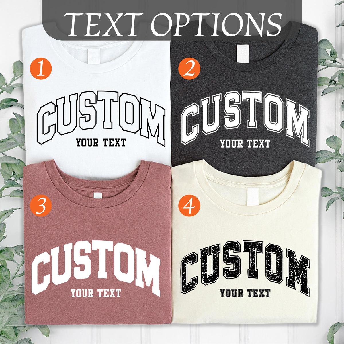 May include: Four t-shirts in white, charcoal, mauve, and cream, each with a custom design. The word "CUSTOM" is arched across the front in a bold, collegiate-style font, with the words "YOUR TEXT" below.