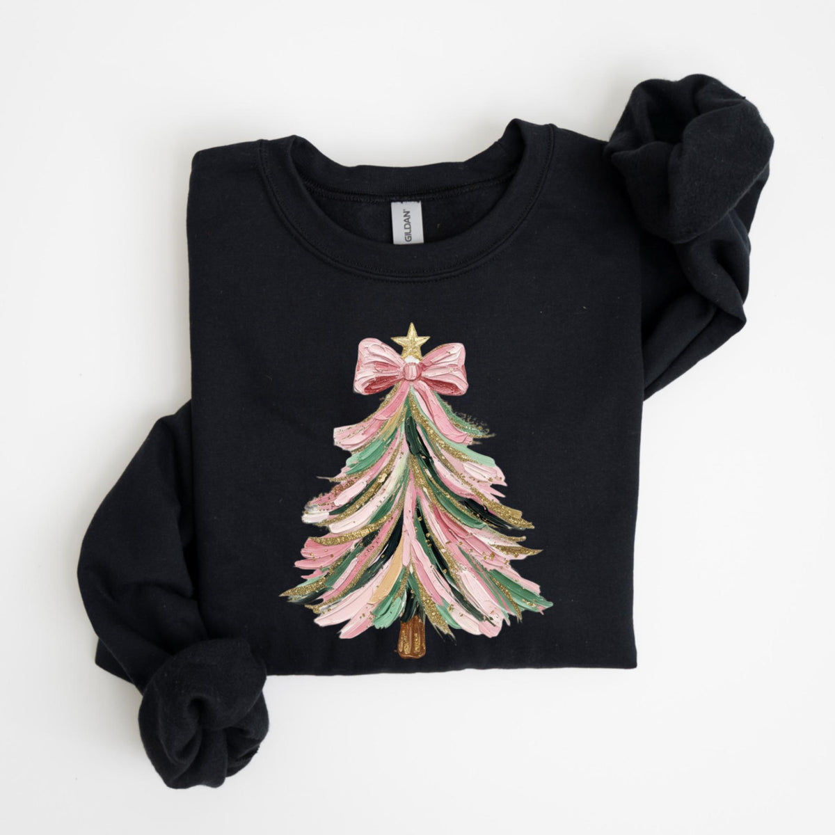 May include: Black sweatshirt featuring a colorful Christmas tree design. The tree is decorated with pink, green, and gold brushstrokes, topped with a pink bow and a gold star. The long-sleeved top is folded.