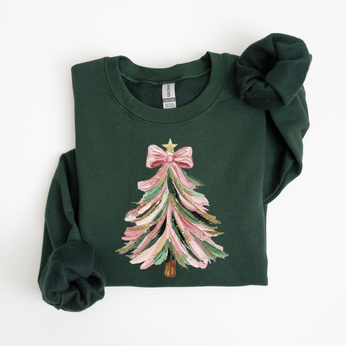 May include: A dark green sweatshirt featuring a Christmas tree design. The tree is painted with pink, gold, and green brushstrokes, topped with a pink bow and gold star. The sweatshirt has long sleeves and a crew neck.