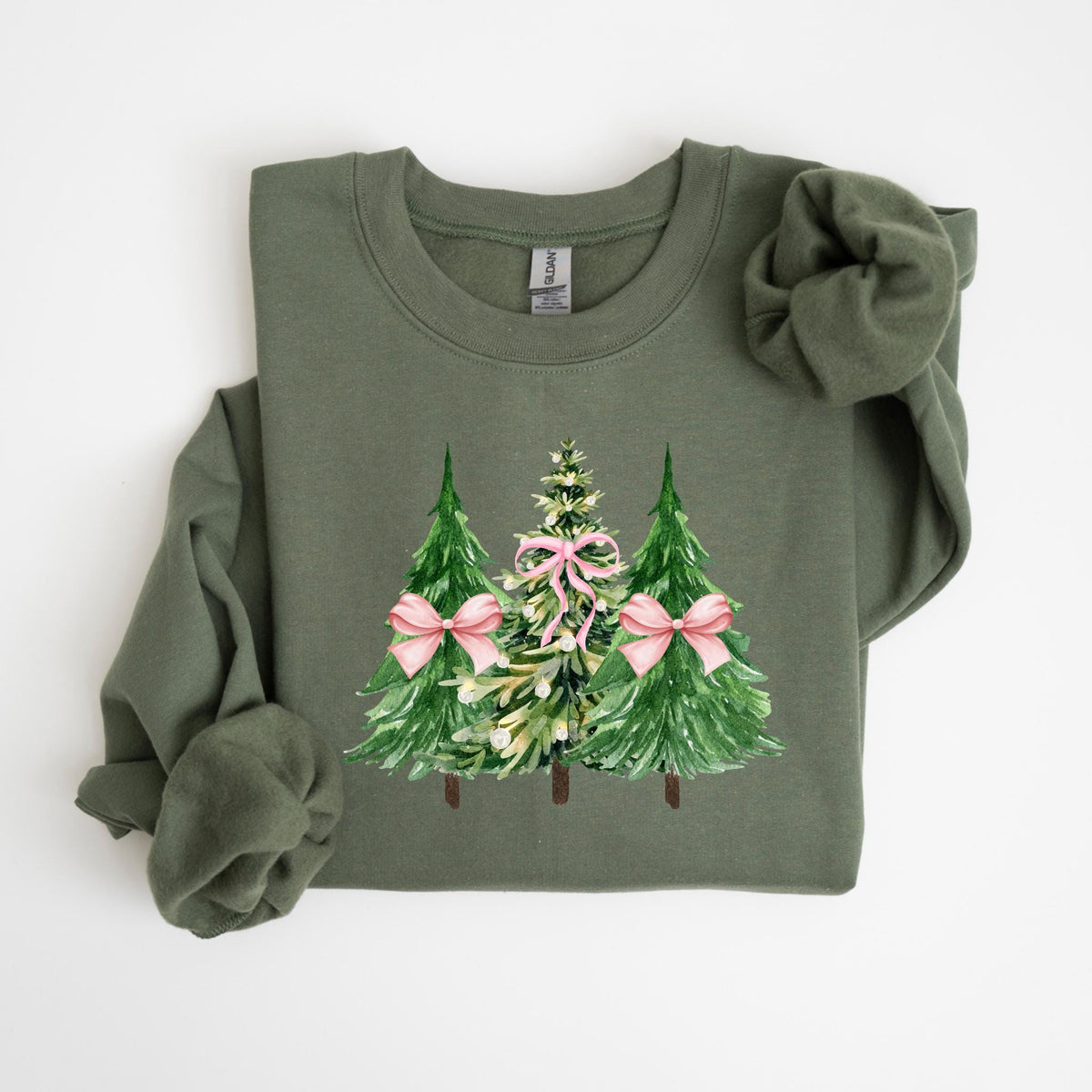 May include: An olive green sweatshirt featuring a watercolor design of three Christmas trees. The trees are green with pink bows and are centered on the front of the sweatshirt. The sweatshirt has long sleeves and a crew neck.