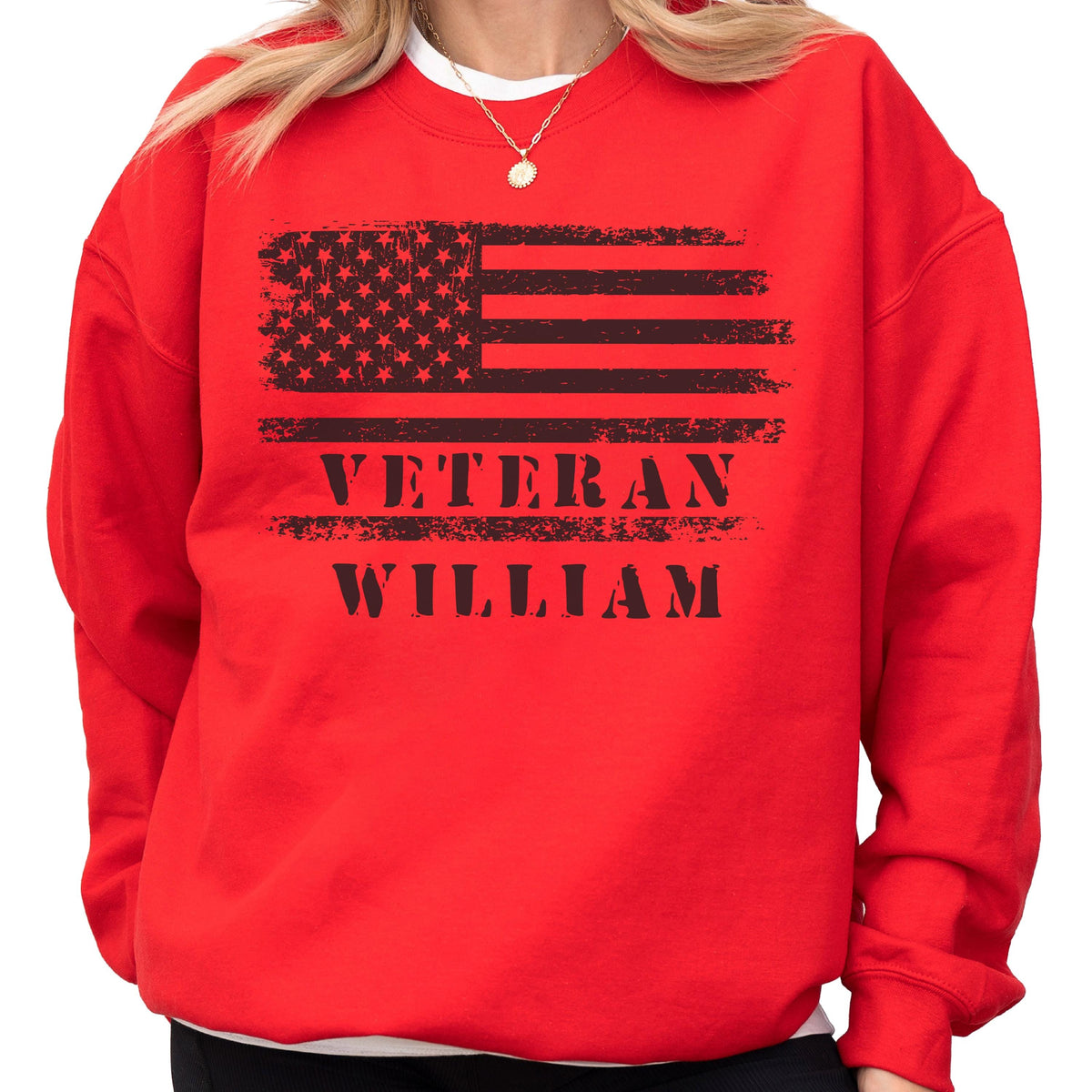 May include: A red sweatshirt featuring a distressed black American flag design. Below the flag, the words "VETERAN WILLIAM" are printed in a bold, black font. The sweatshirt has a crew neck and long sleeves.
