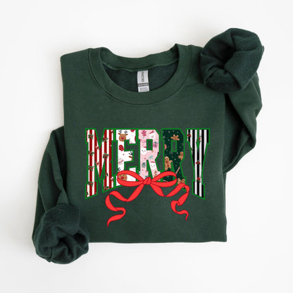 May include: A dark green sweatshirt with the word "MERRY" in a festive design. The letters are filled with holiday patterns, including stripes, gingerbread men, and gift boxes. A large red bow is beneath the word, adding a decorative touch.
