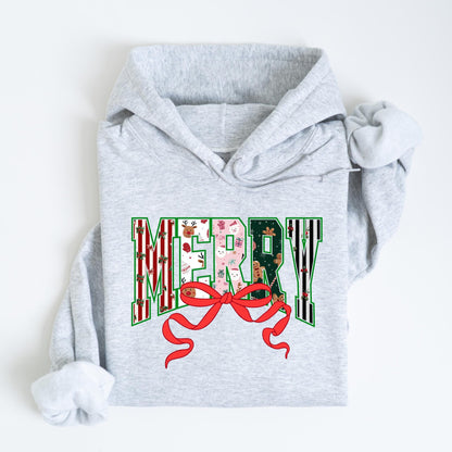 May include: A light gray hoodie with the word "MERRY" in a festive design. The letters are filled with Christmas patterns, including reindeer, snowmen, and gingerbread men. A red bow is at the bottom of the word.