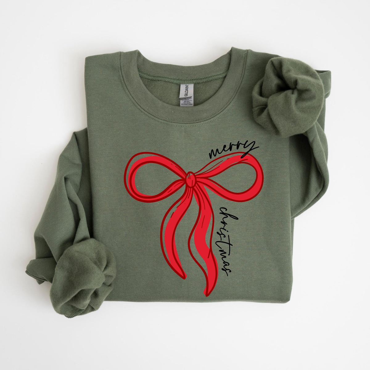 May include: An olive green sweatshirt featuring a large red bow design with the words "merry christmas" in a script font. The long-sleeved top is made of a soft material, perfect for the holiday season.