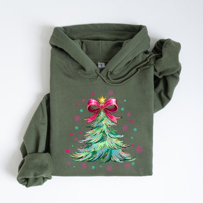 May include: An olive green hoodie featuring a Christmas tree design. The tree is decorated with a pink bow, a gold star, and colorful accents. The hoodie has a drawstring hood and a kangaroo pocket.