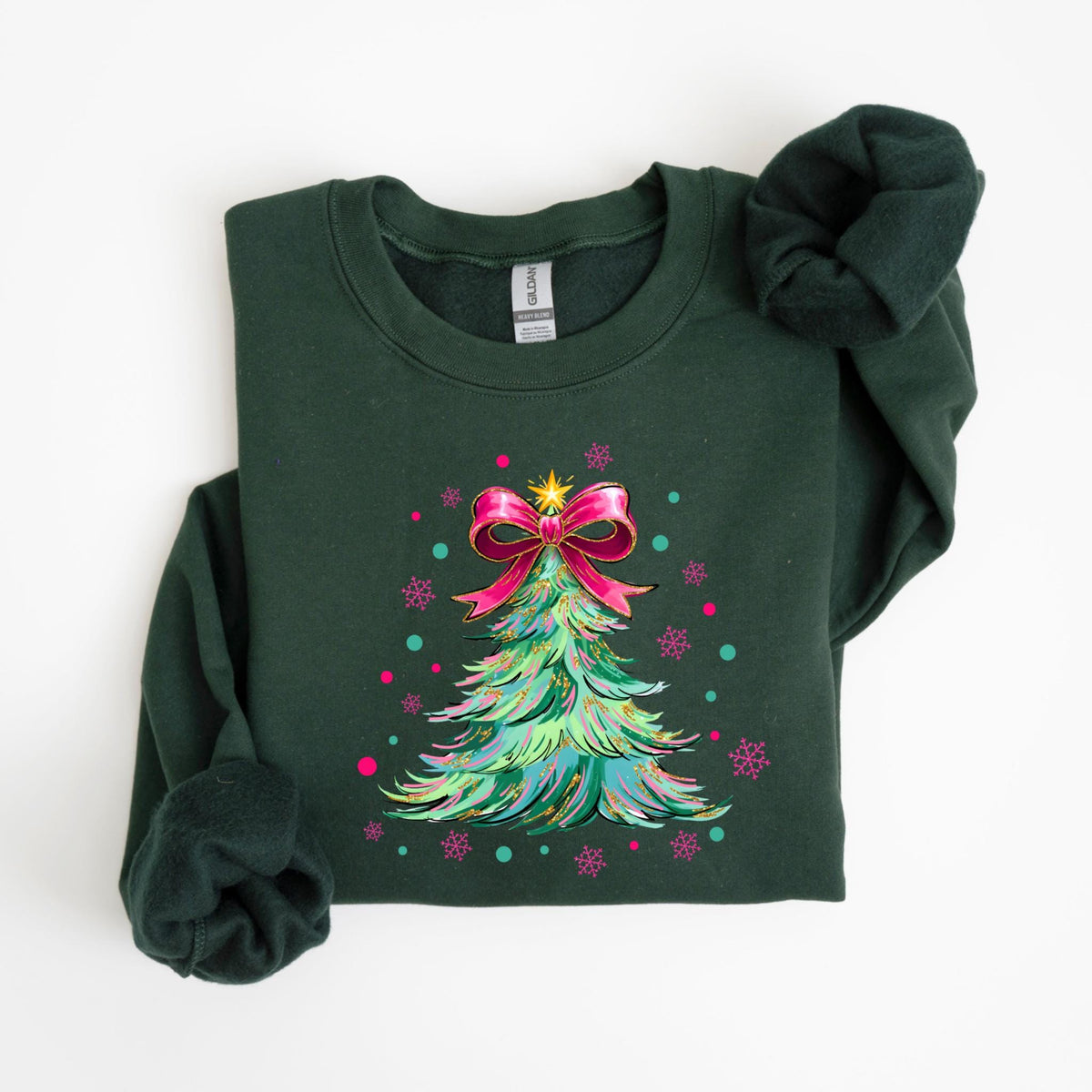 May include: Dark green sweatshirt featuring a colorful Christmas tree design. The tree is adorned with a pink bow, a gold star, and colorful snowflakes. A festive holiday-themed apparel item.