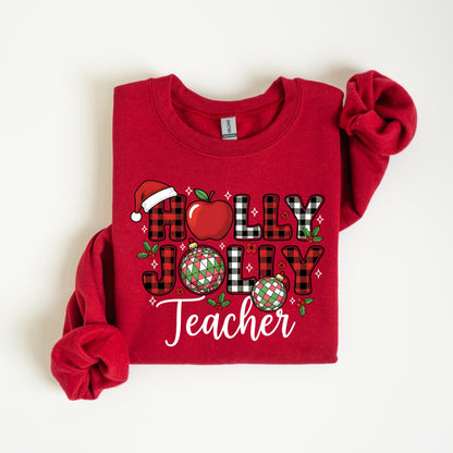 May include: A red sweatshirt with the words "HOLLY JOLLY Teacher" in a festive design. The design includes a Santa hat, an apple, and Christmas ornaments. The letters are in a mix of plaid and solid colors.