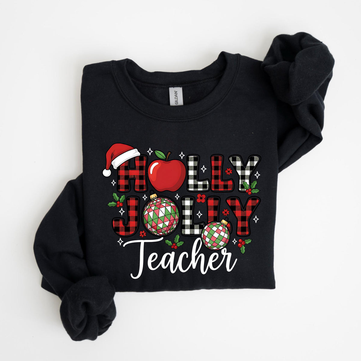 May include: Black sweatshirt with the words "HOLLY JOLLY Teacher" in a festive design. The word "HOLLY" is in red and black plaid, with a Santa hat and apple. The word "JOLLY" is in red plaid, and the word "Teacher" is in white.