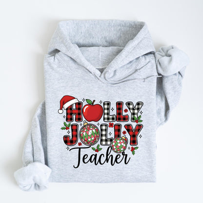 May include: A light gray hoodie with a festive design. The design includes the words "HOLLY JOLLY Teacher" in a mix of red buffalo plaid and black and white checkered patterns, along with a Santa hat, apple, and Christmas ornaments.