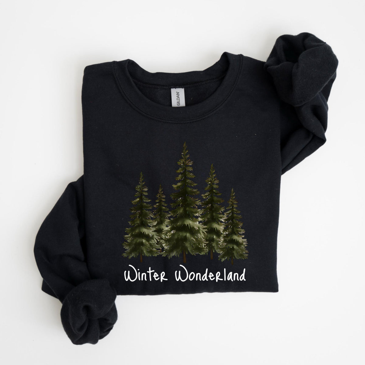 May include: Black sweatshirt featuring a watercolor illustration of evergreen trees. The phrase "Winter Wonderland" is written in white script below the trees. The long-sleeved top is folded neatly.