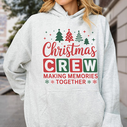 May include: A light gray hooded sweatshirt featuring a graphic print with the text "Christmas CREW MAKING MEMORIES TOGETHER" in red and green. The design includes illustrations of four pine trees and small star and snowflake accents.
