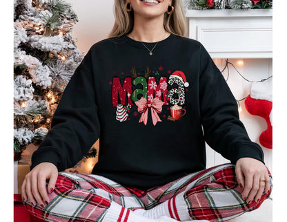 May include: Black sweatshirt with the word "Mama" in a festive Christmas design. The letters are decorated with holiday elements like antlers, a Santa hat, and a bow. A mug of hot cocoa is also featured.