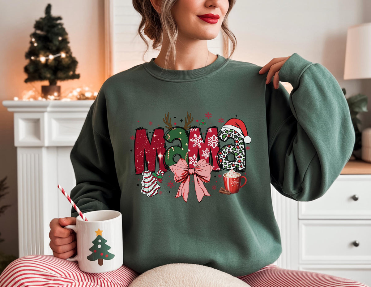 May include: A dark green sweatshirt with the word "MAMA" in a festive Christmas design. The letters are decorated with holiday elements like a Santa hat, bow, and ornaments. A white mug with a Christmas tree design is held in the hand.