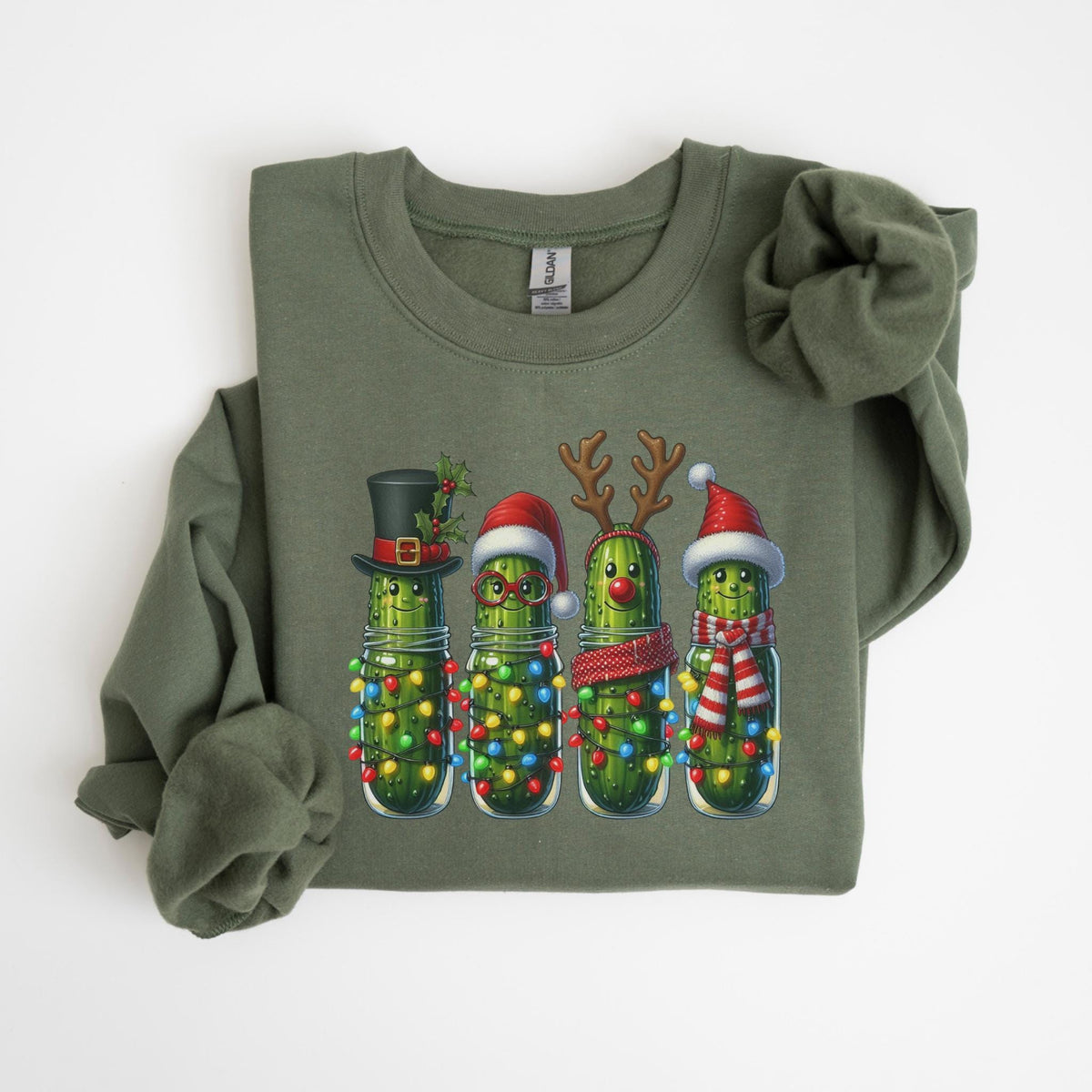May include: Olive green sweatshirt featuring a festive graphic of four anthropomorphic pickles in mason jars. Each pickle is adorned with holiday accessories like a top hat, Santa hat, reindeer antlers, and a scarf, and surrounded by colorful Christmas lights.