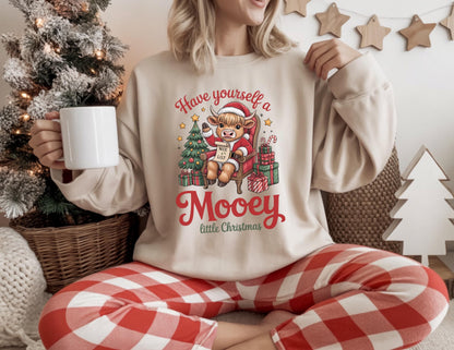 May include: Beige sweatshirt with a Christmas graphic featuring a cow wearing a Santa hat, holding a "Nice List" sign, and the text "Have yourself a Mooey little Christmas." The person is wearing red and white plaid pajama pants.