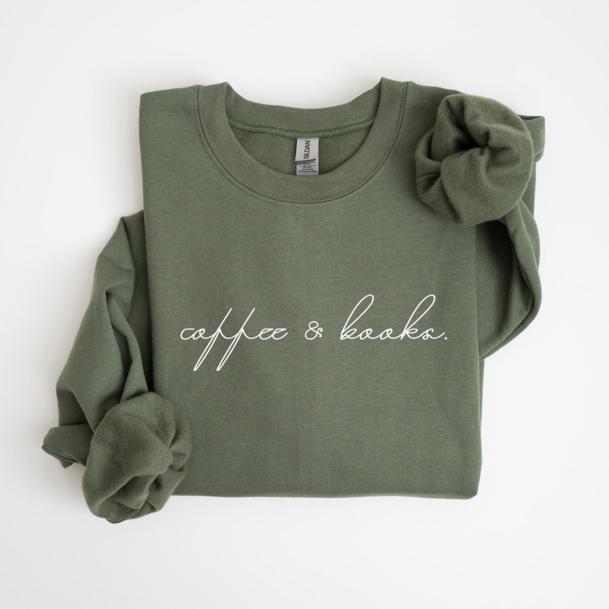 May include: An olive green sweatshirt with the words "coffee & books" in a white script font. The long sleeves are folded. The Gildan brand tag is visible on the collar.