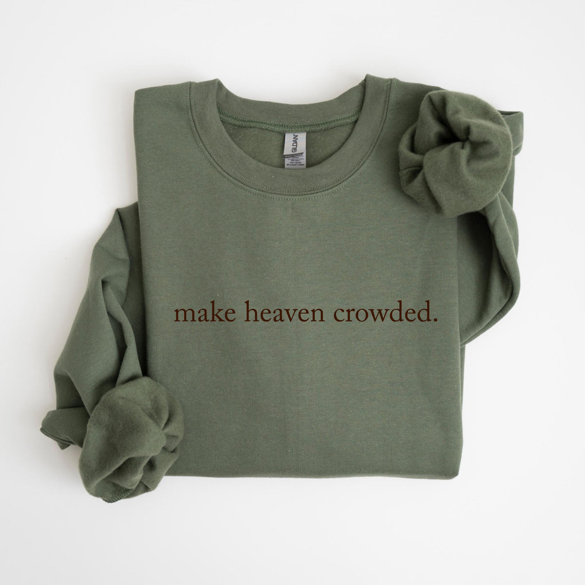 May include: An olive green sweatshirt with the phrase "make heaven crowded." printed in a dark brown color. The sweatshirt has a crew neck and long sleeves, with one sleeve folded over.