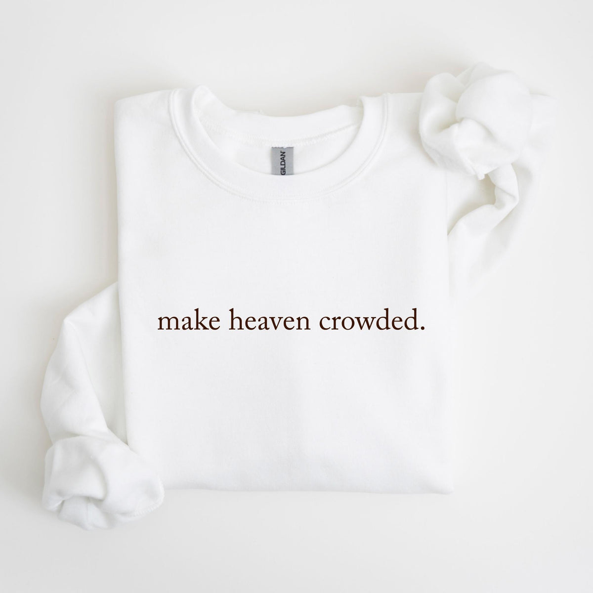 May include: White crew neck sweatshirt with the phrase "make heaven crowded" printed in a dark brown color. The sweatshirt is made of a soft material and has a classic, casual style.