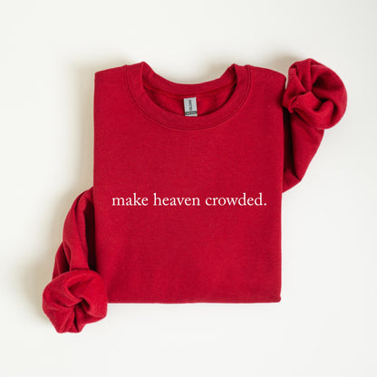 May include: A red crewneck sweatshirt with the phrase "make heaven crowded" printed in white. The sleeves are folded, and the sweatshirt is displayed on a white surface. The Gildan brand tag is visible.