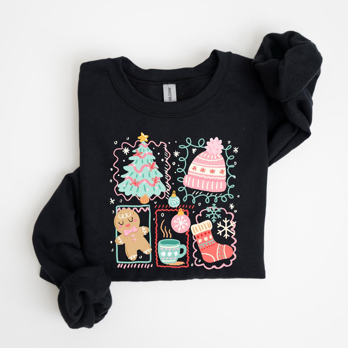 May include: Black sweatshirt with a colorful holiday-themed graphic. The design includes a Christmas tree, a pink hat, a gingerbread man, a mug of hot cocoa, a Christmas ornament, a stocking, and a snowflake, all framed in decorative boxes.