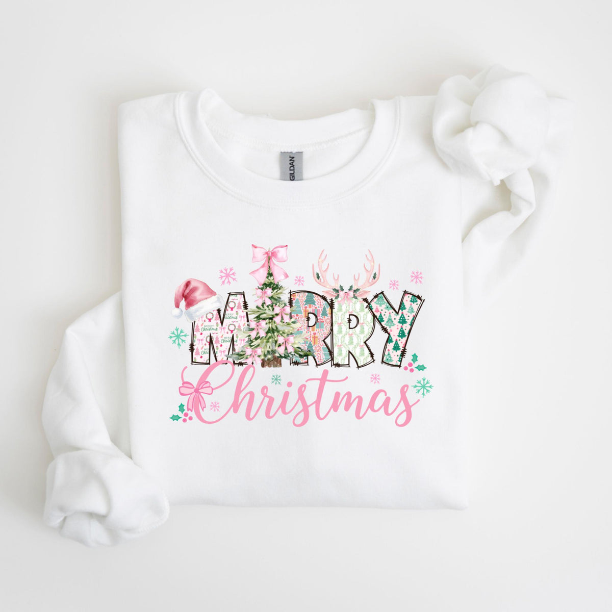 May include: White sweatshirt with a festive "Merry Christmas" design. The design features a Santa hat, Christmas tree, and reindeer antlers, with the words in a mix of patterns and colors, including pink and green. The text "Christmas" is in a cursive font.