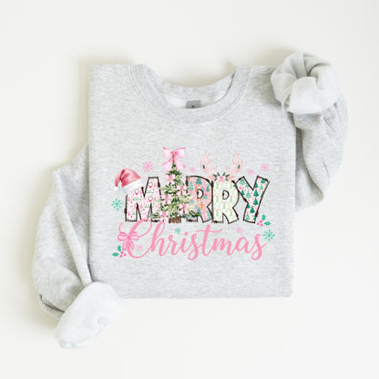 May include: A light gray sweatshirt with a festive "Merry Christmas" design. The design features a Christmas tree, reindeer antlers, and the words "Merry Christmas" in a mix of fonts and colors, including pink and green.