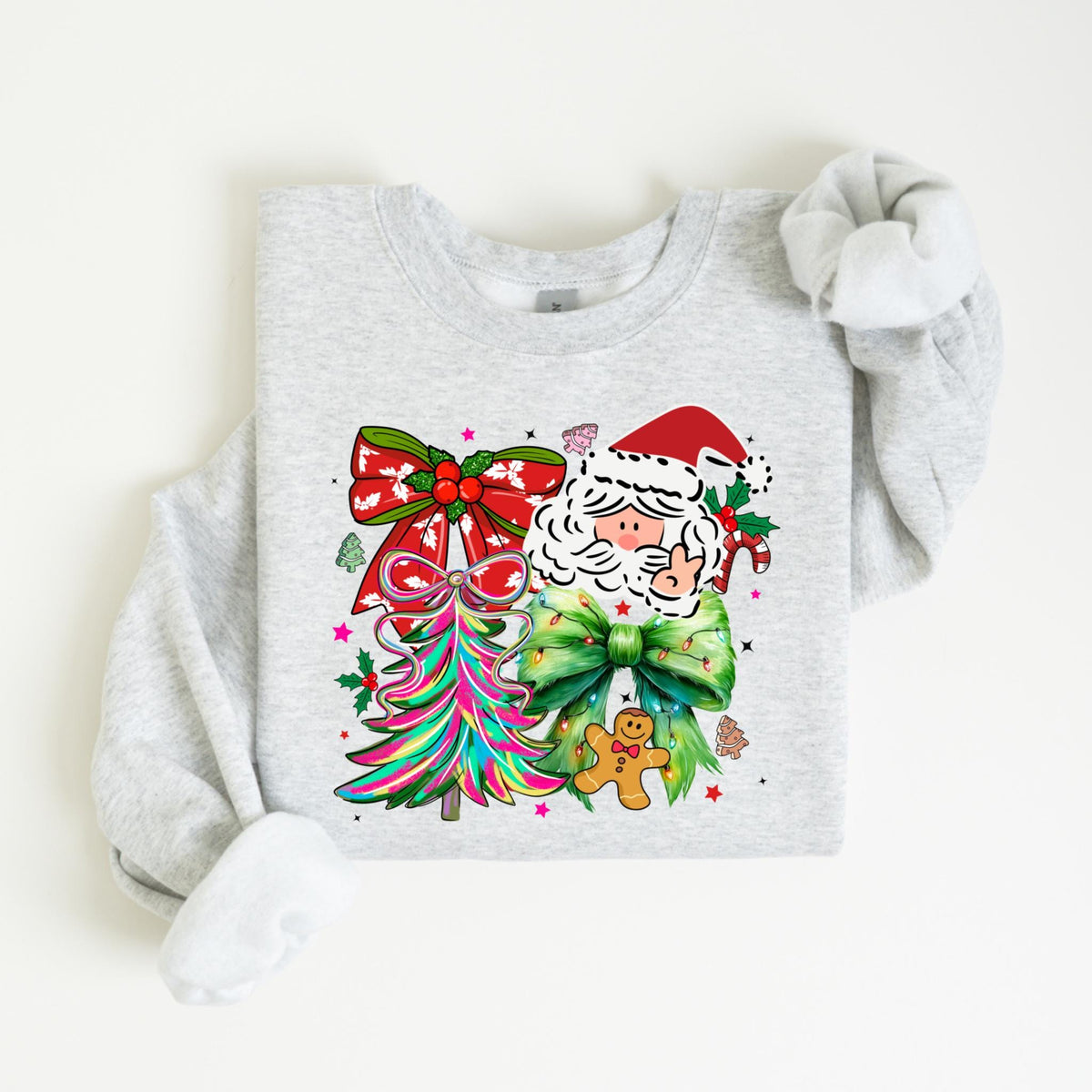 May include: A light gray sweatshirt featuring a colorful Christmas design. The design includes a Santa Claus face, a Christmas tree, and a gingerbread man. The Santa Claus is wearing a red hat and has a white beard. The Christmas tree is multi-colored.
