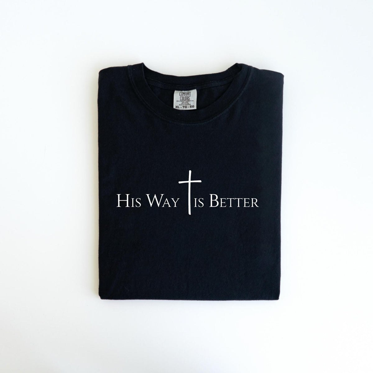 May include: Black t-shirt with the text "His Way Is Better" in white, along with a white cross symbol. The shirt is folded neatly and is centered on a white background.