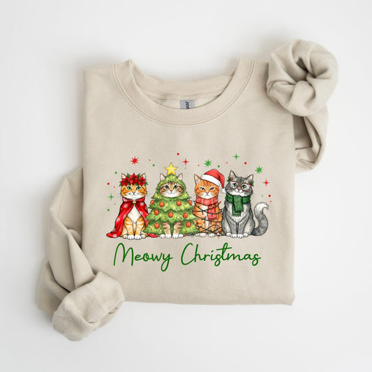 May include: A beige sweatshirt featuring a festive design with four cats dressed for Christmas. One cat wears a red cape and wreath, another is a Christmas tree, and others wear a Santa hat and scarf. The words "Meowy Christmas" are written in green.
