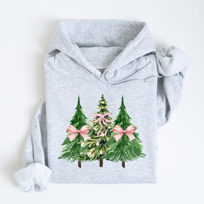 May include: A light gray hoodie featuring a watercolor design of three Christmas trees. The trees are green with pink bows, creating a festive holiday theme. The hoodie has a drawstring hood and long sleeves.