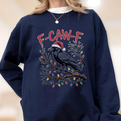 May include: A navy blue crewneck sweatshirt featuring a graphic of a black crow wearing a red and white Santa hat. The crow is perched on a bare tree branch wrapped in colorful Christmas lights. The text F-CAW-F is printed in red above the bird.