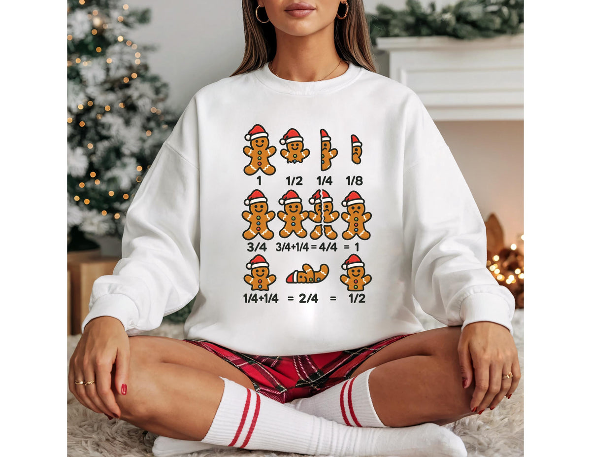 May include: White sweatshirt featuring gingerbread men wearing Santa hats, with fractions displayed above and below them. The text includes fractions like 1/2, 1/4, and 1/8, and equations such as 3/4 + 1/4 = 4/4 = 1.