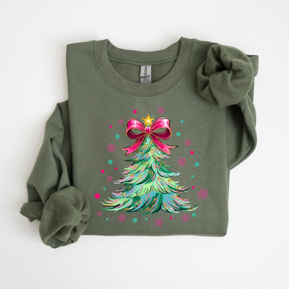 May include: Olive green sweatshirt featuring a Christmas tree design. The tree is decorated with a pink bow, a gold star, and colorful accents. The design includes pink snowflakes and teal dots, creating a festive holiday theme.