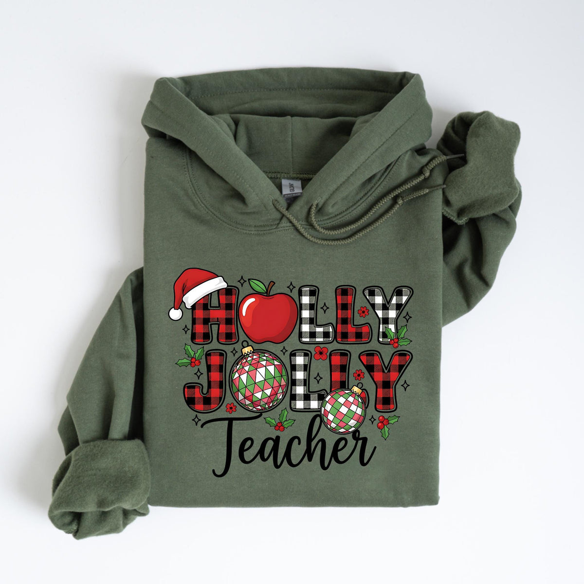 May include: An olive green hoodie with the words "Holly Jolly Teacher" in a festive design. The design includes a Santa hat, apple, plaid letters, and Christmas ornaments, perfect for the holiday season.