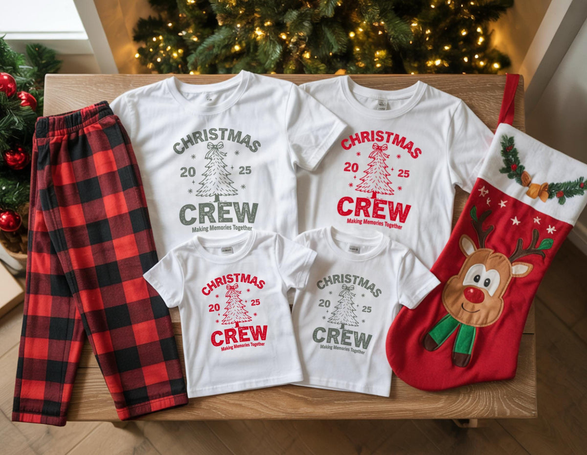 May include: A collection of Christmas-themed apparel and accessories. Includes white t-shirts with "Christmas Crew" text and a tree graphic, red and black plaid pajama pants, and a red Christmas stocking with a reindeer design.
