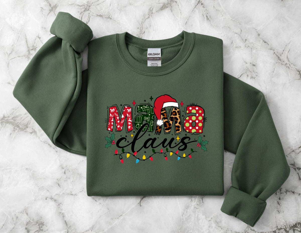 May include: Olive green sweatshirt with the text "Mama Claus" in a festive design. The word "Mama" is in red plaid, green, and leopard print. The word "Claus" is in a black script font with colorful Christmas lights.