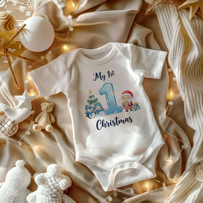 May include: White short-sleeved baby onesie with the text "My 1st Christmas". The onesie features a blue number 1, a Christmas tree, penguins, and Santa Claus. The onesie is made of soft material and has snap closures.